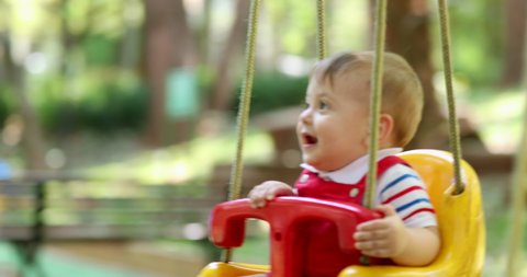 
Adorable cute baby infant boy child at playground swinging