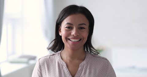 Happy african american millennial ethnic woman looking at camera laughing at home in office, confident young adult mixed race lady dental smile close up face portrait, healthy teeth whitening concept