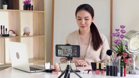 4k video of Famous blogger. Cheerful female vlogger is showing cosmetics products while recording video for everyday makeup tutorial. at work.