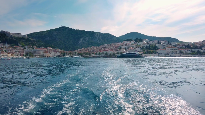 Trail of waves behind the sailing boat, as it leave the coast od Hvar