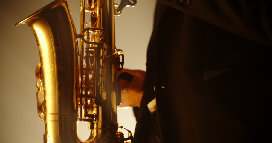 Cool saxophonist wearing a suit and performing an amazing solo. Musician doing a concert with jazz band - music, arts concept 4k footage