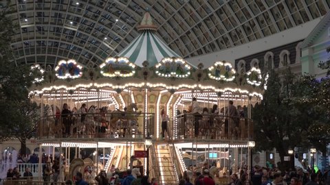Moscow, Russia - February 29 2020: People on spinning carousel at "Dream island" amusement park. Modern shopping mall interior.