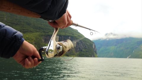 Close up of woman fishing with a fishing rod in Norway. Fishing in Norway is a way to embrace the local lifestyle. 
