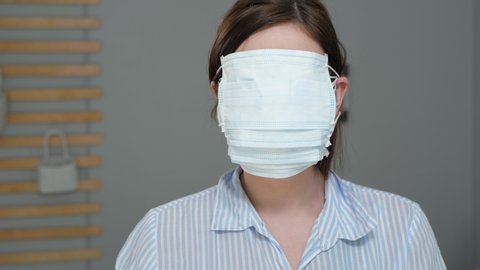Maximum protection for cold, flu, virus, acute respiratory infections, quarantine, epidemic, irony, sarcasm concept. Attractive girl puts on surgical mask, then one more and one more ...