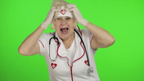 Portrait of elderly caucasian female doctor dance. Crazy and funny nurse. Green screen. Chroma key