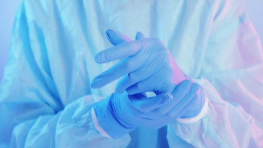 Covid pandemia breakout. Medical staff protection. Female physician wearing blue latex gloves on hands. Royalty-Free Stock Footage #1047512359