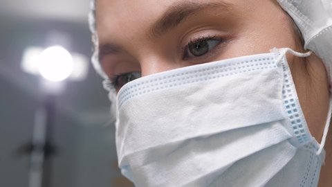 Doctor woman in mask. Close-up face of female doctor in medical mask at work. Operation, practitioner, operating room, surgery, transplantation, medicine concept