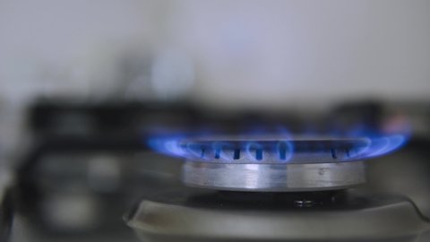 Kitchen burner turning on.Stove top burner igniting into a blue cooking flame.