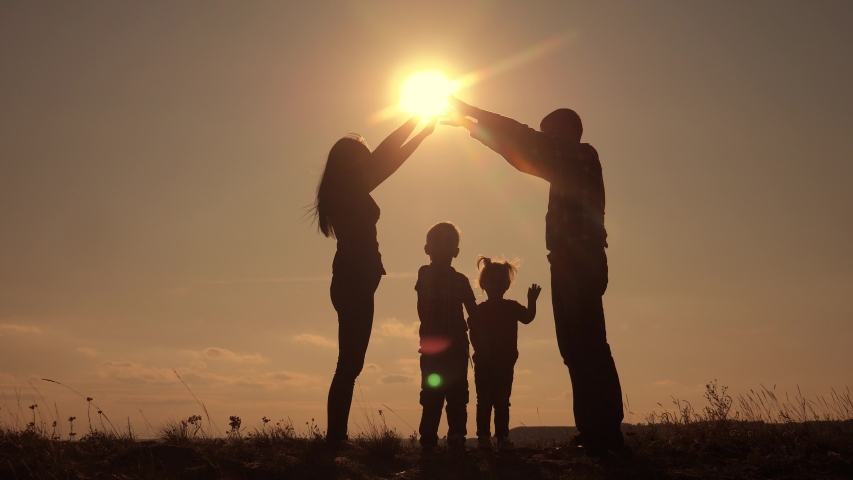 happy family teamwork silhouette shows a house and comfort symbol home at sunset. happy family mom dad and kids children portray a house roof hold their hands lifestyle over their heads home Royalty-Free Stock Footage #1047542350