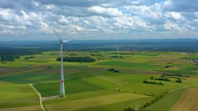 Aerial view of fields and wind turbine around Kaltenhof in Germany.  Camera pans left, panorama shot.