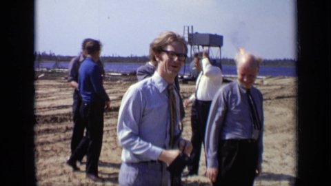 MOSCOW RUSSIA-1971: Group Of Men And A Reporter Look Over The New Construction Sight On A Windy Day