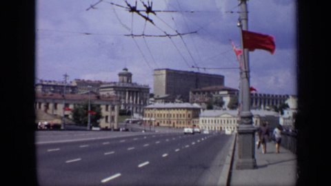 MOSCOW RUSSIA-1971: Urban City Streets With Oncoming Traffic And A Brisk Wind