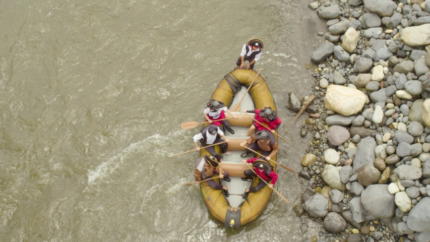 shot from above of pirates paddling hard to set sail