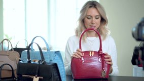 Fashion blogger recording herself on video demonstrating handbag. Social media marketing. Product promotion. Working from home