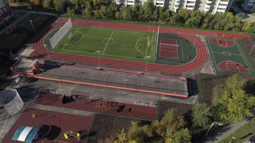 People play sports. Stadium, basketball court and treadmills in the yard in the city. Aerial.
Ekaterinburg city, Russia