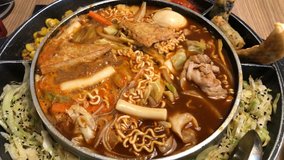 Korean Hot pot 'Budae Jjigae' with  yellow noodle soup stew is Korean fusion food incorporates American style with noodle