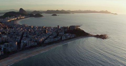 Aerial wide angle panning view of famous Copacabana Beach at sunrise, Rio de Janeiro. Sugarloaf Mountain in the background.
