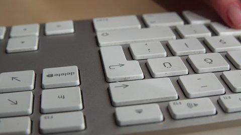 Close up on white keyboard buttons and fingers writing and pressing enter key