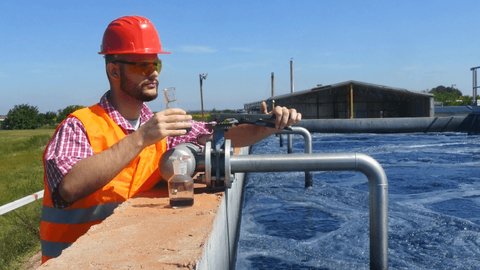   An engineer controlling a quality of water ,aerated activated sludge tank at a waste water treatment plant.  pollution 