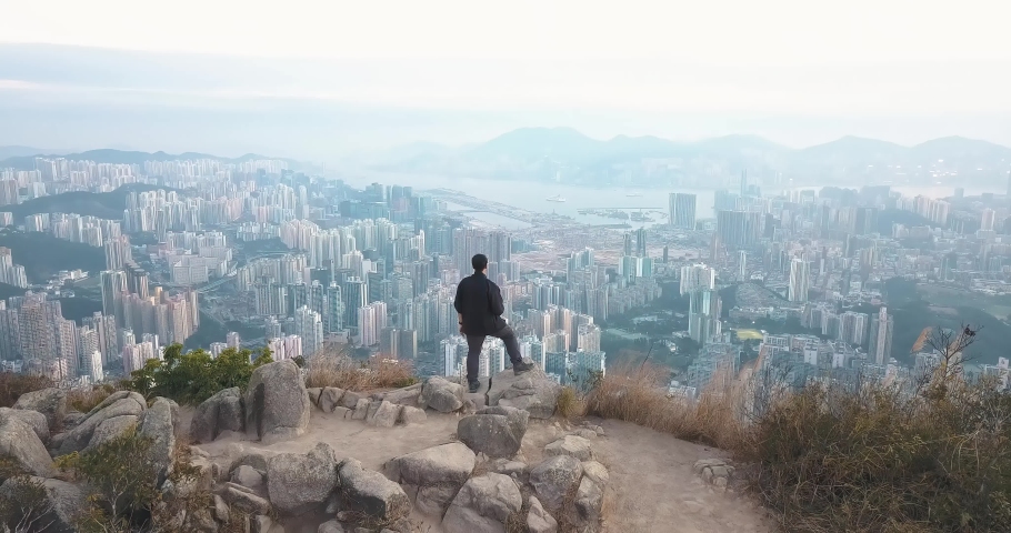 Drone Aerial View of Man standing on Top of Lion Rock with Hong Kong City in Background