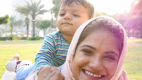 Mother and little son spending time together at the park. Muslim family outdoor in Dubai. Lifestyle moments in the UAE