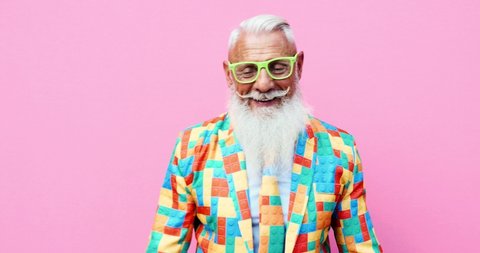 Senior man hipster with funny colored outfit on colored backgrounds
