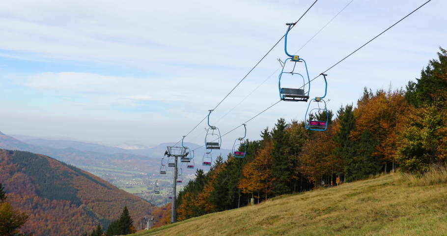 Funicular out of service which used during the winter season for skiers view of seats swinging in strong wind while looking at the landscape and surrounding nature in Pustevny Beskids region 4k 60fps