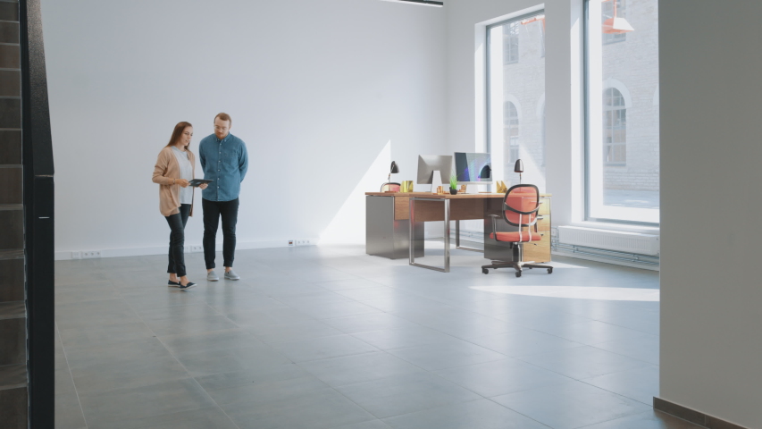 In Empty New Office: Female Interior Designer and Male Office Architect Talk, Use Augmented Reality Software on Digital Tablet Computer to Choose, Move and Manipulate 3D Furniture. VFX Special Effects Royalty-Free Stock Footage #1047633154