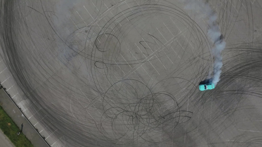 Aerial View Of Driver Training Drifting On Sports Car. Green Car Does Dangerous Tricks.