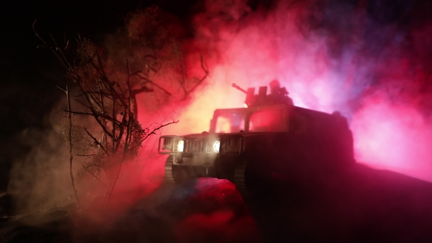 War Concept. Battle scene on war fog sky background, Fighting silhouettes Below Cloudy Skyline at night. Army vehicle with soldiers artwork decoration. Selective focus