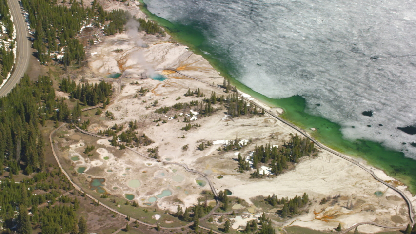 The West Thumb Geyser Basin features dramatic, colorful geothermal features, and sits next to a frozen Yellowstone Lake, in Yellowstone National Park