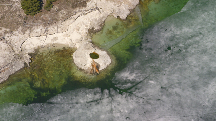 The West Thumb Geyser Basin features dramatic, colorful geothermal features, and sits next to a frozen Yellowstone Lake, in Yellowstone National Park
