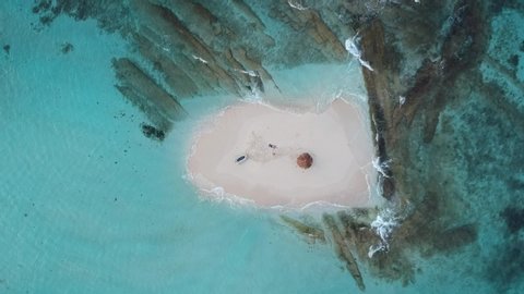 Île Morpion, or Morpion Island, a tiny deserted looking island or cay with a straw umbrella, in St Vincent and the Grenadines, near the private Palm island.