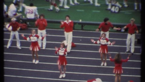 ITHACA NEW YORK-1979: Cheerleaders Cheering During Football Game After A Throw And Tackle Of Opposing Teams