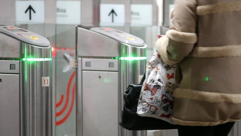 Moscow, Russia - February 29, 2020: Unrecognizable people pass through the entrance turnstiles of Moscow Metro. Contactless ticket system in the subway. Passengers apply RFID cards to readers