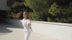 Youngster girl dance and spin around in city