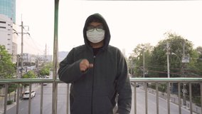 Asian Man Standing at Bangkok City Using Medical Mask are Protect CoVID-19 (Novel Coronavirus 2019). Man Coughing Under a Medical Mask. Footage B Roll for Advertising or Medical Technique.