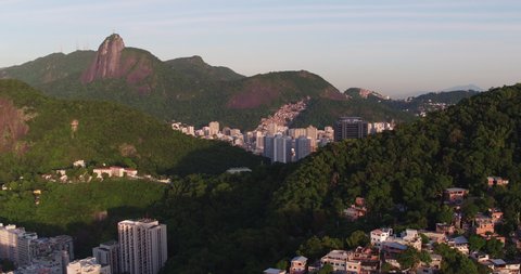 Flying above favela on the mountain slope to reveal city of Rio de Janeiro and Botafogo Bay with boats, Brazil