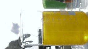 Scientists conducts chemical reaction in large glass with reagents in modern laboratory close-up on unfocused background, smartphone vertical screen