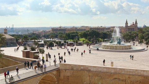 Valletta, Malta - 01182020: The Triton fountain, people on the square, bridge, church on background