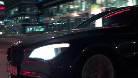 Bucharest, Romania - 02.20.2020: Crane rolling shot detail view of a BMW 7 Series luxury sedan car driving on a street at night 