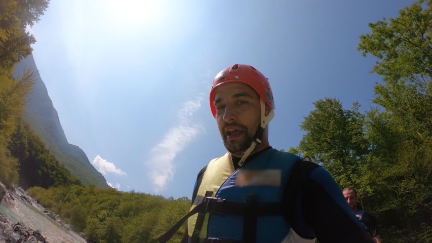 Man doing selfie canyoning jump into the clear blue river from the rock