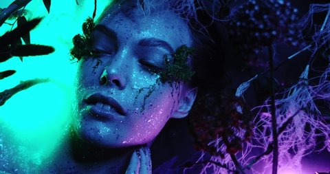 Fantasy world, a fabulous beautiful girl nymph or woman elf looks at the camera and poses with bright neon colors blue and purple creating magic around her fog, close-up portrait 4k quality