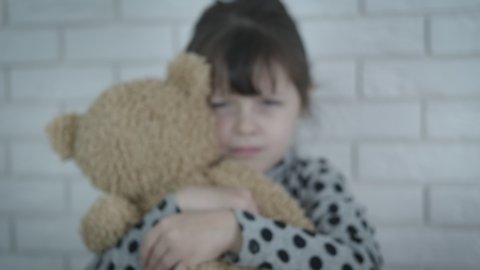 Stop child abuse. Depressed lonely child with teddy show with her hand to stop a family abuse at home.
