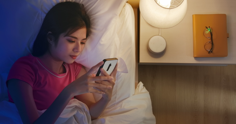 IOT AI smart home concept - Asian woman talk with voice assistant to turn off the lights of house at home while sleeping | Shutterstock HD Video #1047732157