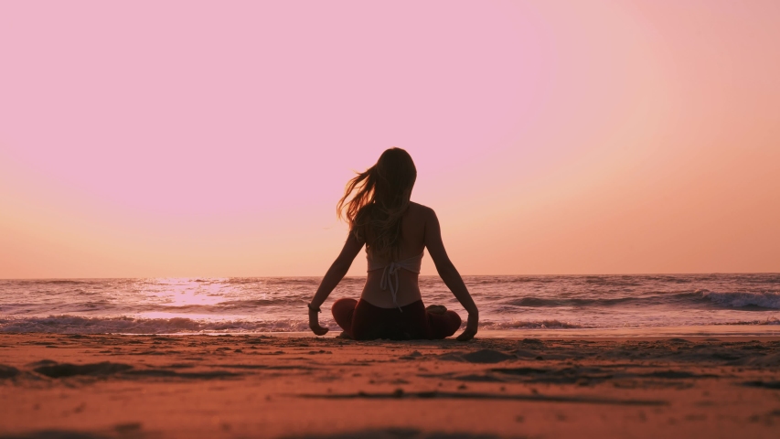 Beautiful free and wild woman sitting in meditation pose on the Indian beach lotus position medicine yoga asana balance kundalini energy every day routine practice good for woman health mindfulness | Shutterstock HD Video #1047734764