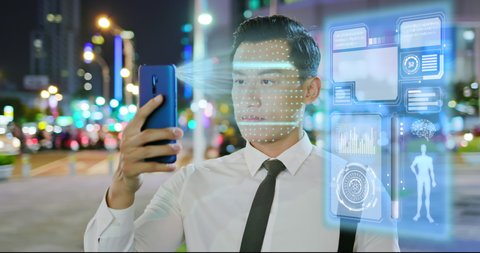 businessman use facial recognition system by smartphone at night