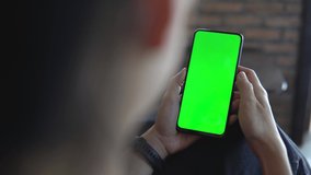 woman using smartphone with green screen in tram chroma key smartphone technology. Close up footage.