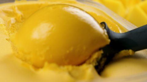 close up on scooping mango ice cream