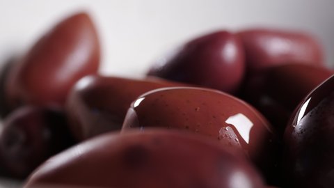 Fresh delicate gourmet kalamata olives with olive oil in extreme close up macro